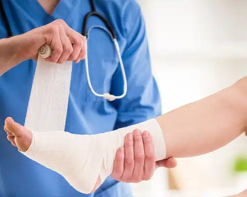 Doctor wrapping sprained ankle<br />
